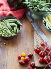 Still life of fresh vegetables with vine tomatoes, peas and okra — Stock Photo