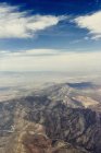 Воздушный вид скалистых гор под голубым облачным небом — стоковое фото
