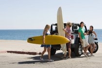 Friends by vehicle with surfboards — Stock Photo