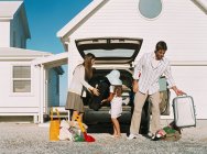 Family unpacking luggage from the car — Stock Photo