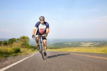 Man cycling on open road — Stock Photo