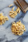 Freshly made pasta varieties on marble surface — Stock Photo