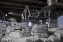 Milling machines and stacks of sacks in wheat mill — Stock Photo