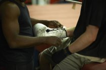 Entrenador ayudando boxeador ponerse guantes, sección media - foto de stock