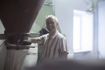 Porträt des männlichen Müllers, der die Mahlmaschine an der Weizenmühle überwacht — Stockfoto
