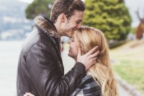 Jovem romântico beijando namoradas testa, Lago de Como, Itália — Fotografia de Stock