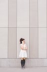 Женщина перед зданием делает телефонный звонок, Милан, Италия — стоковое фото