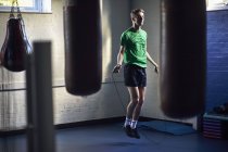 Jeune boxeur masculin sautant dans la salle de gym — Photo de stock
