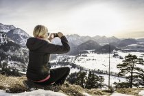 Jeune randonneuse photographiant les Alpes Allgau sur smartphone, Bavière, Allemagne — Photo de stock