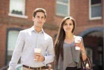 Young businessman and woman with takeaway coffee, London, UK — Stock Photo