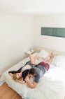 Couple couché sur le lit parlant à la maison — Photo de stock