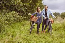 Ehepaar schiebt Fahrrad auf ländlichem Weg — Stockfoto