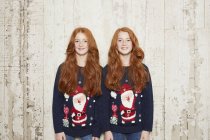 Retrato de irmãs gêmeas usando camisolas de Natal — Fotografia de Stock