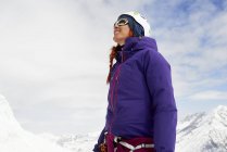 Femme sur une montagne enneigée levant les yeux souriant, Saas Fee, Suisse — Photo de stock
