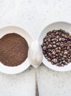 Vista superior de grãos de café e café moído em tigelas — Fotografia de Stock