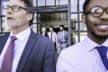 Close up de empresários saindo do prédio de escritórios — Fotografia de Stock