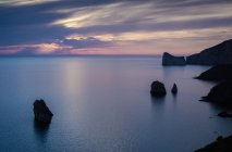 High angle silhouetted view of rock formations and cliffs at dusk, Masua, Italy — Stock Photo