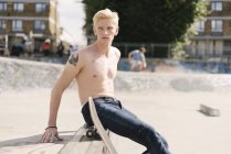 Junger männlicher Skateboarder schaut im Skatepark über die Schulter — Stockfoto