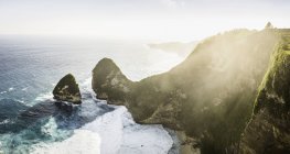 Sonnenbeschienener Blick auf Felsformationen und Küste mit Brandungswellen — Stockfoto
