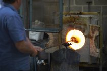 Ventilador masculino caucásico en taller usando horno - foto de stock