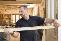 Man quality checking wooden plank — Stock Photo