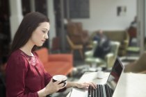 Donna d'affari che lavora con il computer portatile in caffè — Foto stock