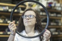Mulher na loja de reparação de bicicletas verificação de qualidade do tubo interno — Fotografia de Stock