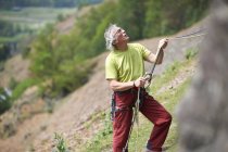 Bergsteiger hält Kletterseil in der Hand und schaut nach oben — Stockfoto