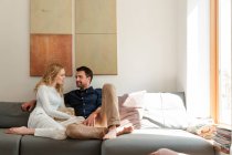 Couple snuggling on sofa together at home — Stock Photo