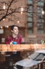 Man looking through window of cafe — Stock Photo