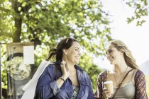 Duas mulheres amigas com takeaway café conversando no parque, Franschhoek, África do Sul — Fotografia de Stock