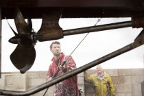 Художник-мужчина очищает корпус корабля с мойщиком давления во дворе корабельных художников — стоковое фото