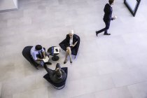 Високий кут зору бізнес-леді і чоловіків зустрічаються в офісному атріумі — стокове фото