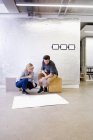 Young Architects in office discussing blueprints — Stock Photo