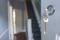 Fermeture de la porte d'entrée de la maison avec clé en serrure — Photo de stock