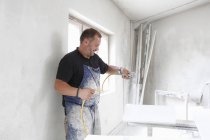 Mann sprüht in Werkstatt Farbe auf Holz — Stockfoto