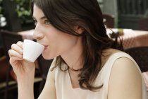 Woman at sidewalk cafe drinking espresso, Milan, Italy — Stock Photo