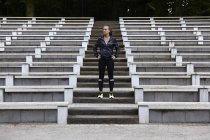 Молода жінка тренується, готуючись бігати по сходах стадіону — стокове фото