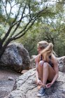 Frau sitzt auf Felsen und bindet Schnürsenkel — Stockfoto