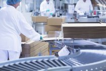 Рабочие упаковывают фармацевтическую продукцию на производственной линии на фармацевтическом заводе — стоковое фото