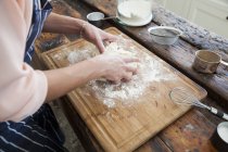 Imagem cortada de mulher amassar massa de farinha no balcão da cozinha — Fotografia de Stock