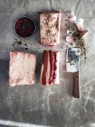 Raw beef short ribs with meat cleaver and peppercorns, top view — Stock Photo