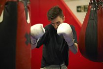 Boxer working out, using punch bag — Stock Photo