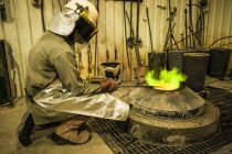 Männlicher Gießereiarbeiter nimmt Temperatur des Ofens in Bronzegießerei — Stockfoto