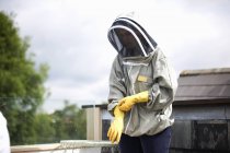 Пчеловод в пчелином костюме, готовится к осмотру улья — стоковое фото