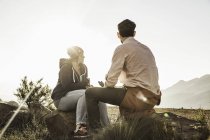 Couple sitting on rocks in field at daytime — Stock Photo
