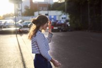 Young woman walking on sunlit street — Stock Photo