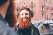 Jeune mâle hipster jumeaux avec des cheveux roux et barbe parler sur la rue — Photo de stock