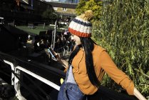 Giovane donna in piedi sul ponte pedonale, guardando smartphone — Foto stock