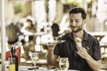 Mann in Bürgersteig-Café mit Eistüte und Pizza-Scheibe — Stockfoto